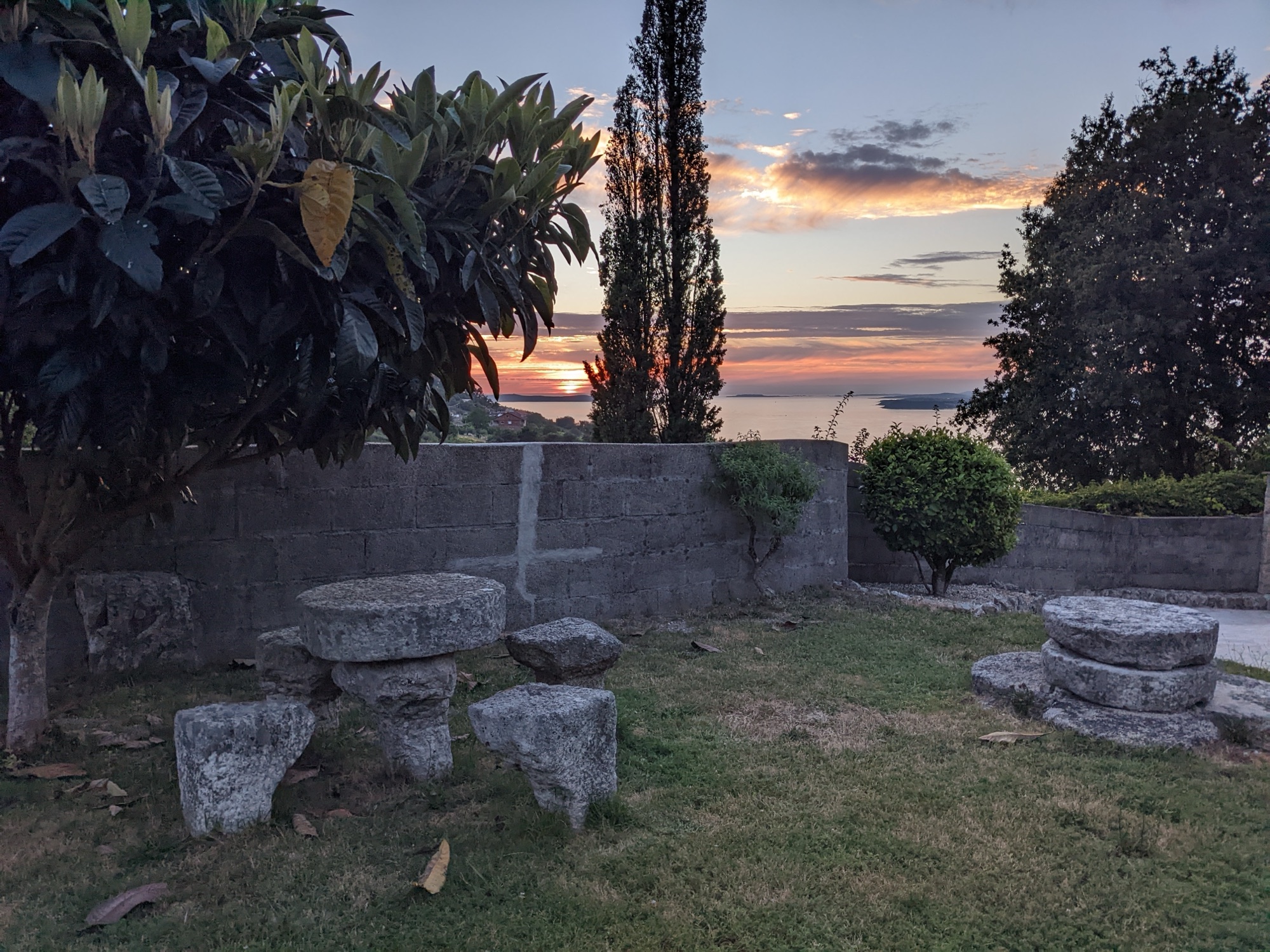 Jardín con mesa de piedra gallega al atardecer